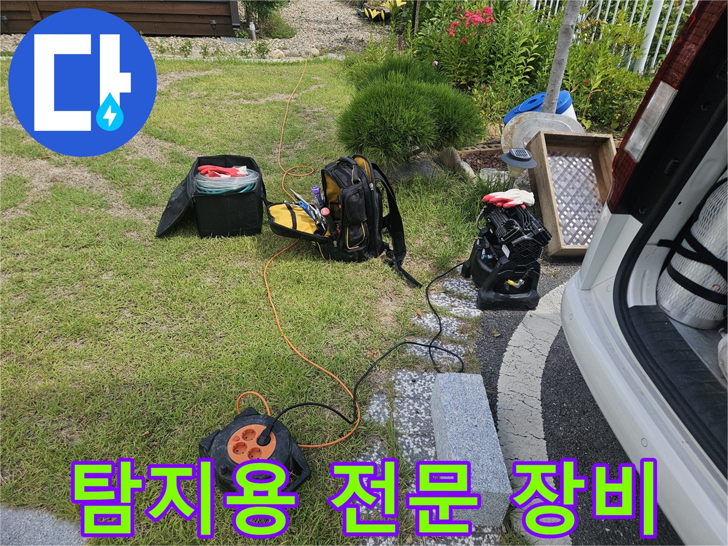 잔디밭에 놓인 가스 탐지기와 전기 연결 릴 세트