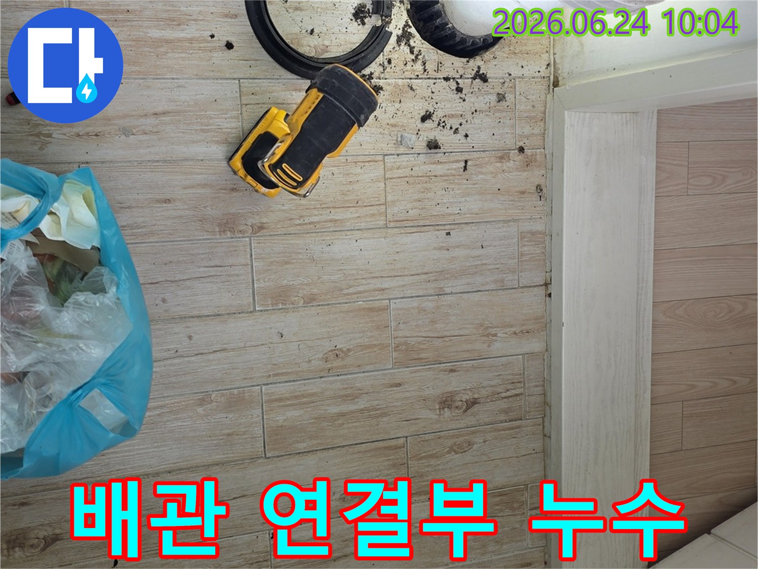 배관 연결부에서-발생한 누수로-오염된 바닥과-수리 중인 현장입니다