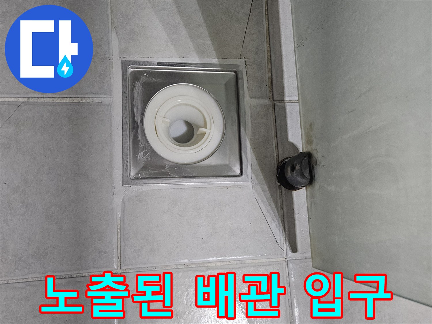 타일 바닥에 드러난 하수구 배관과 주변 마감재 상태