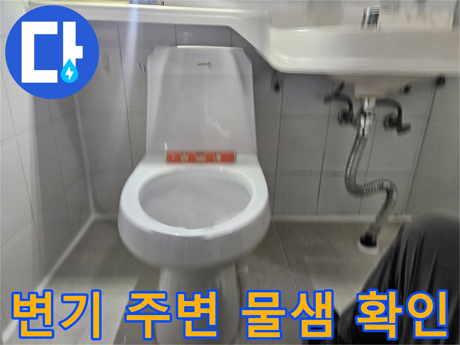 화장실 변기 하단부와 세면대 배관 상태를 촬영한 사진입니다.