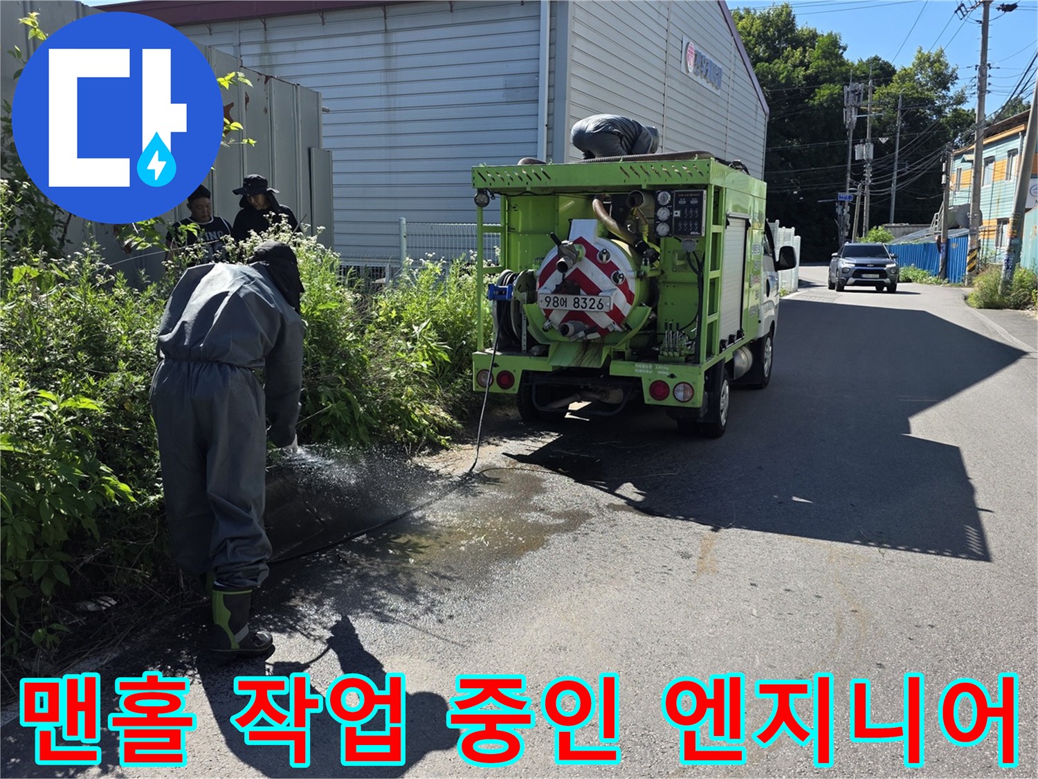 작업자가 맨홀 주변의 이물질을 확인하며 준설 작업을 준비하고 있습니다.