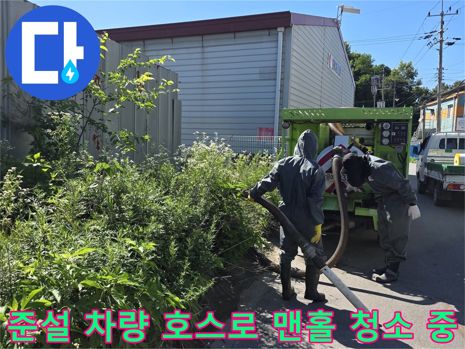 현장에서 준설 차량의 굵은 호스를 이용해 - 맨홀 내부 오염 물질을 흡입하는 장면
