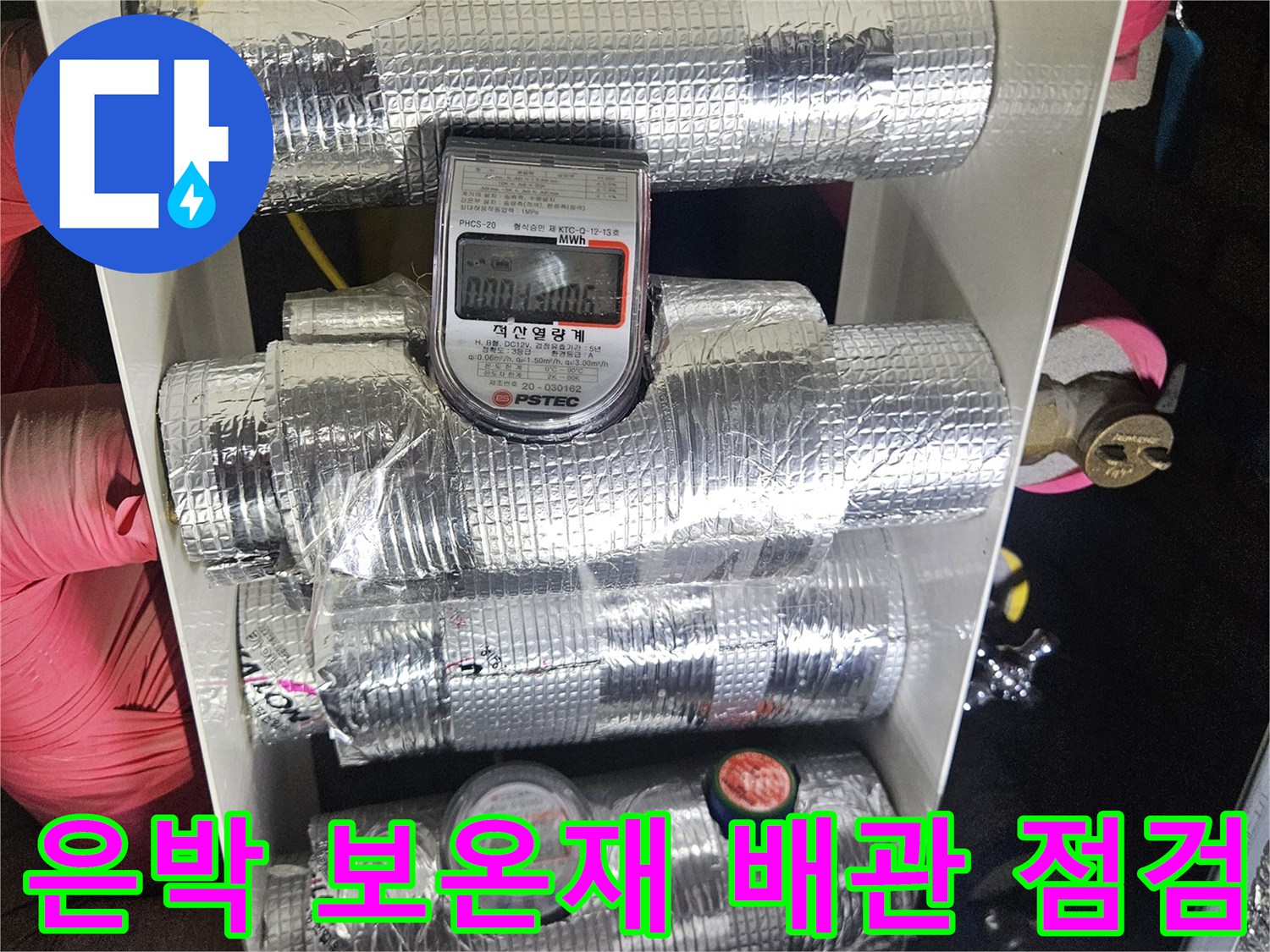 은박 테이프로 마감된 배관과 수도 계량기가 설치된 천장 내부 전경