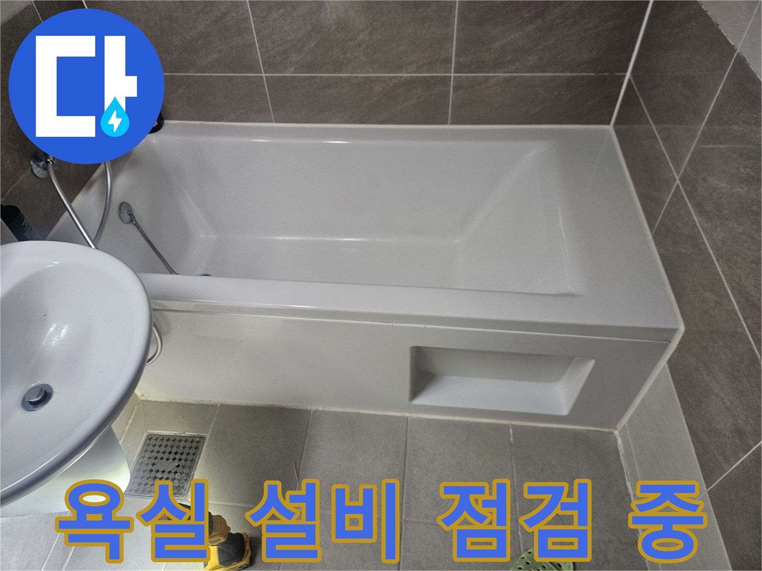 점검 도구가 놓인 욕실의 욕조와 세면대 모습