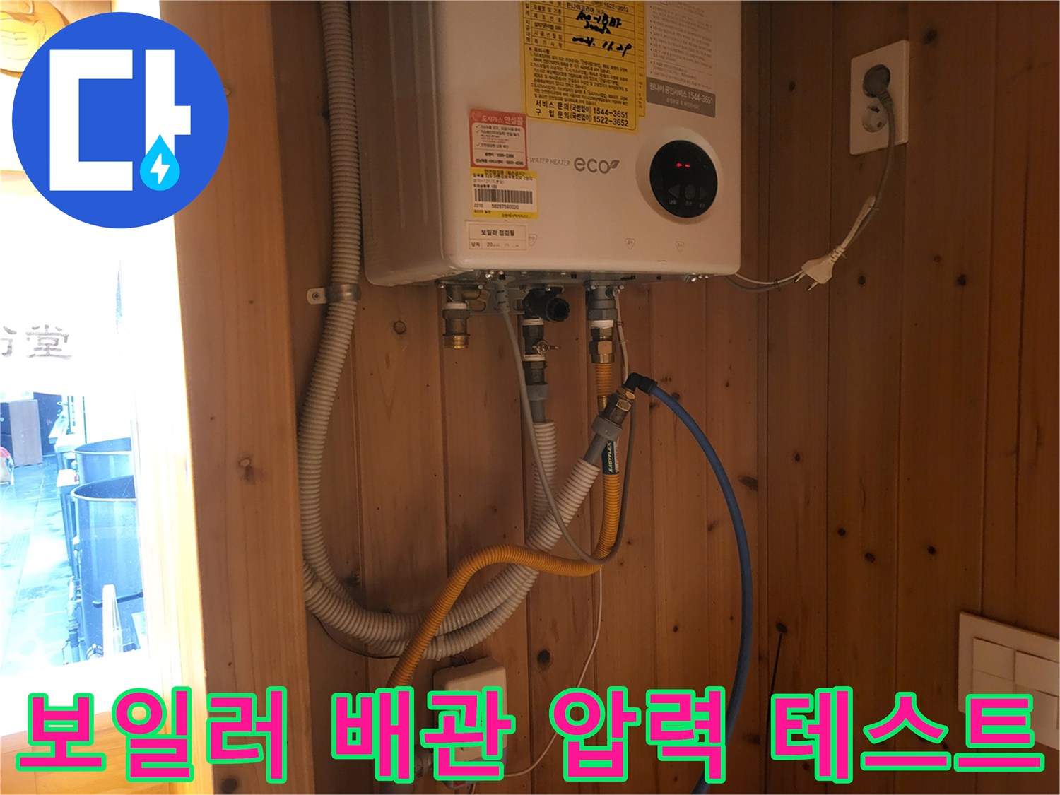 보일러 하단 배관에 연결된 압력계와 각종 호스들의 모습입니다.