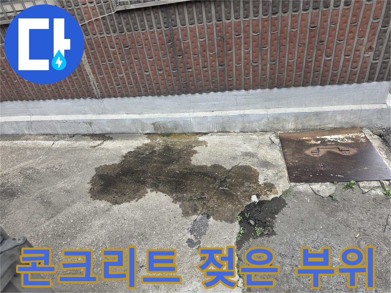 축축하게 젖어 있는 외부 콘크리트 지면과 맨홀