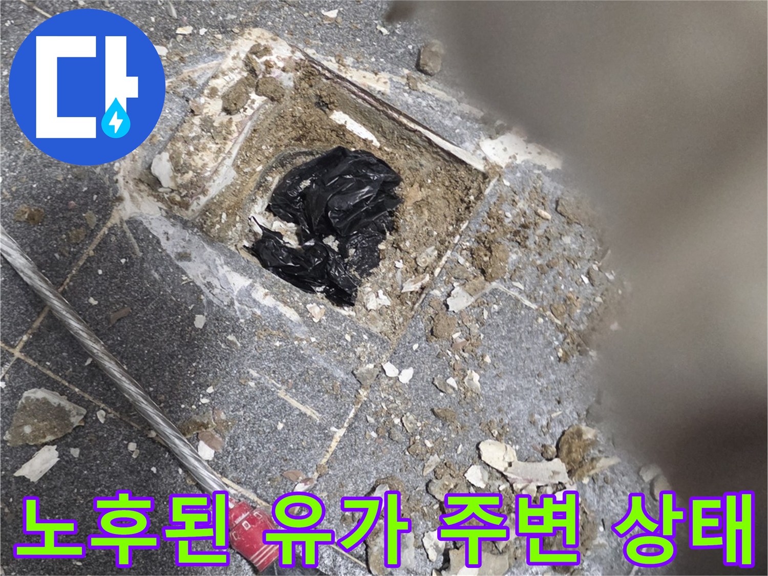 배수구 주변의 깨진 타일과 노출된 배관 구조