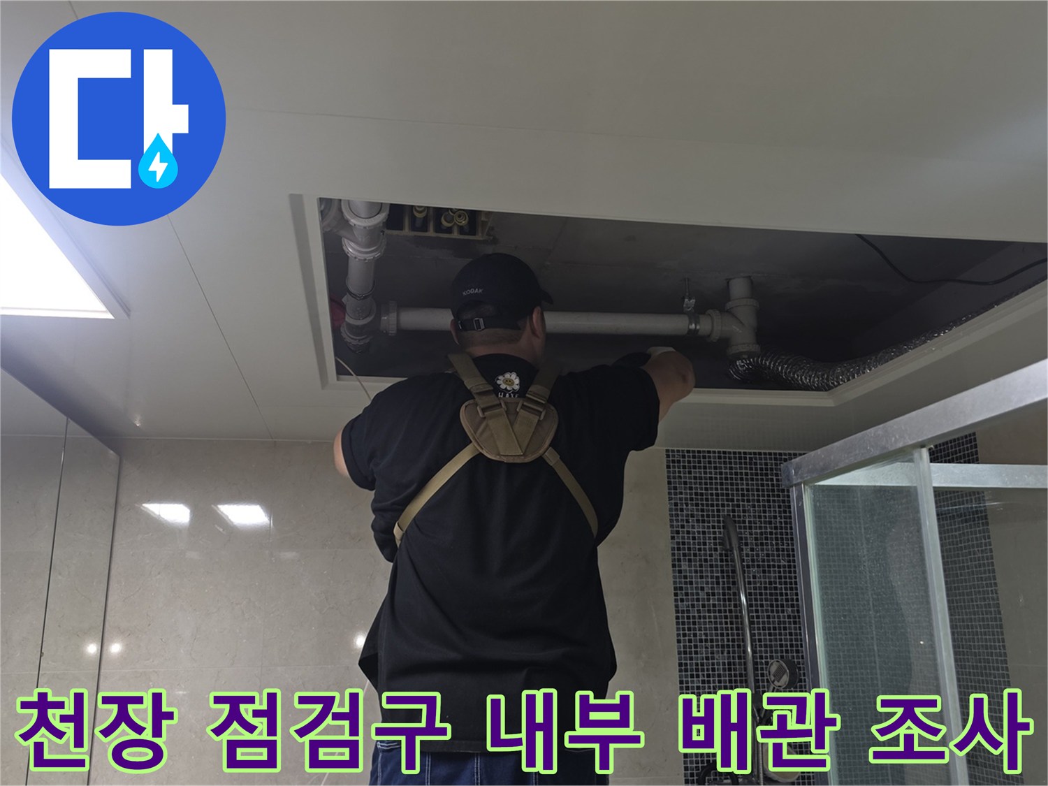 점검구 너머로 보이는 흰색 급수 배관과 작업자 손