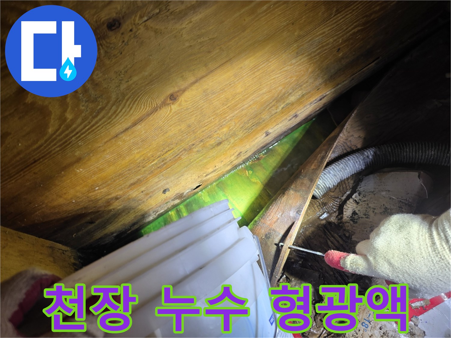 어두운 천장 내부에서 형광물질로 누수 원인을 파악하는 전문 기술자의 작업 현장