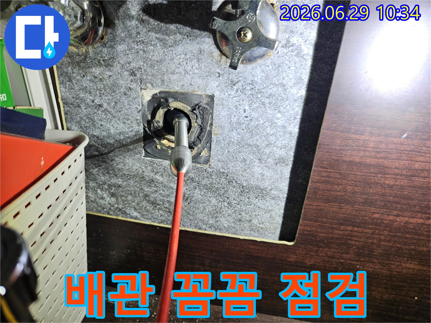 욕실 벽면 내부의 배관 상태를-내시경 카메라로 꼼꼼하게 점검하며-잠재적인 문제점을 찾아내는 전문적인 검사 과정
