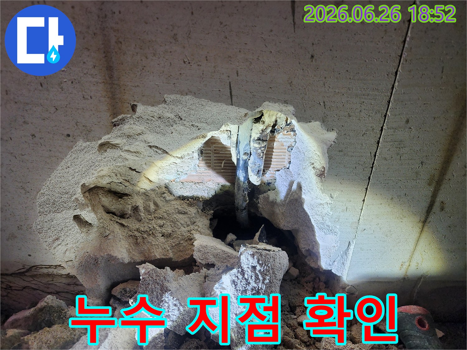 누수 공사를 위해 벽면을 파쇄하여 노출된 배관의 모습입니다
