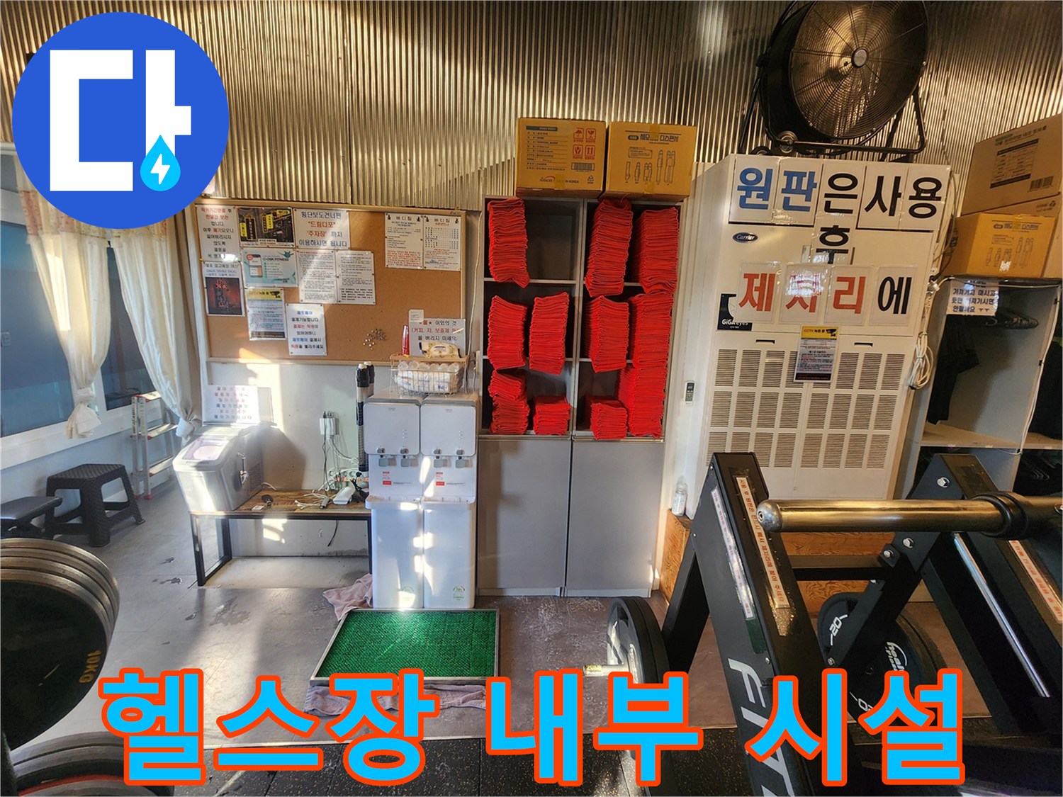 수건 보관함과 운동 기구가 있는 헬스장 탈의실