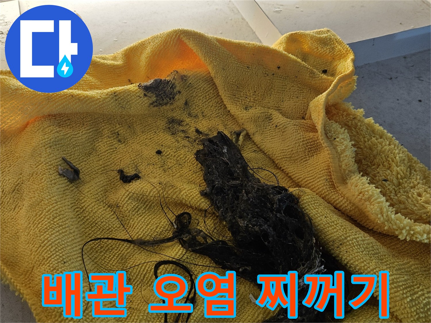 노란 천 위에 쌓인 검은색 머리카락 및 슬러지
