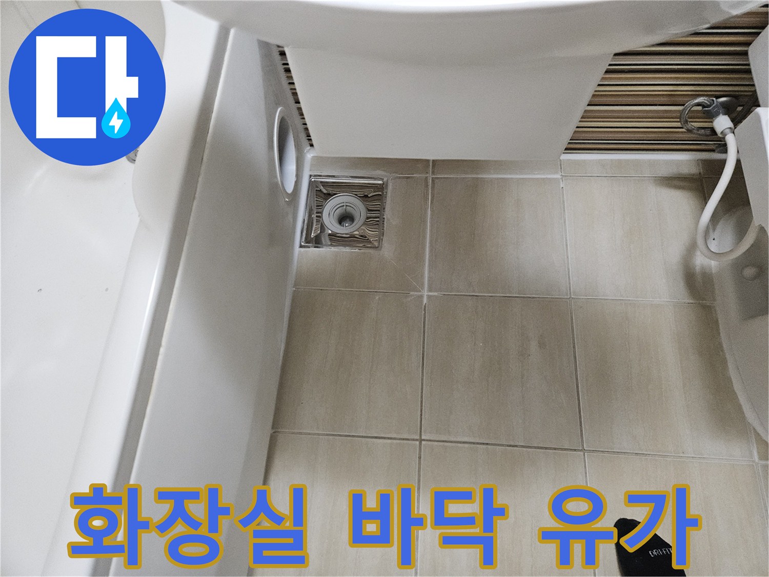 욕실 바닥 타일과 금속 재질의 하수구 유가가 연결된 모습입니다.