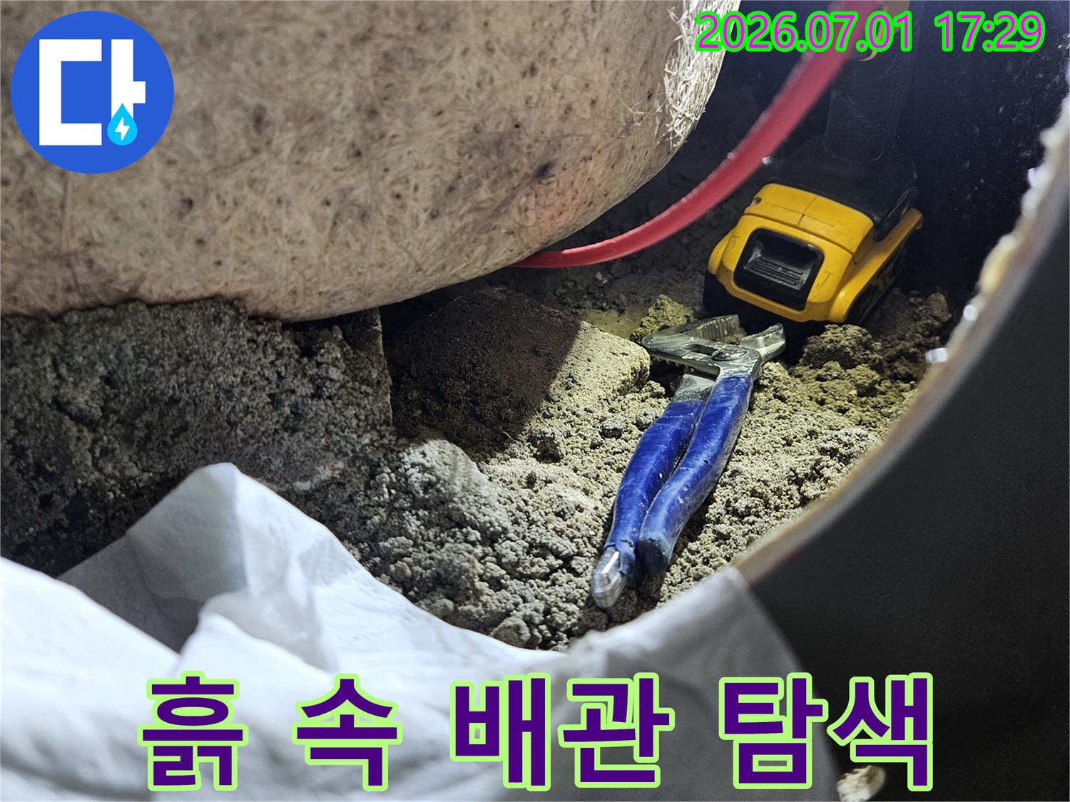 협소한 공간에서 누수 지점을 찾기 위해-작업자가 집중하는 순간을 담은 이미지입니다