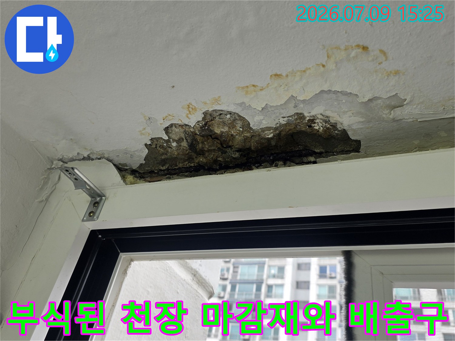거뭇하게 오염되고 부풀어 오른 세탁실 배수부 근처의 벽면