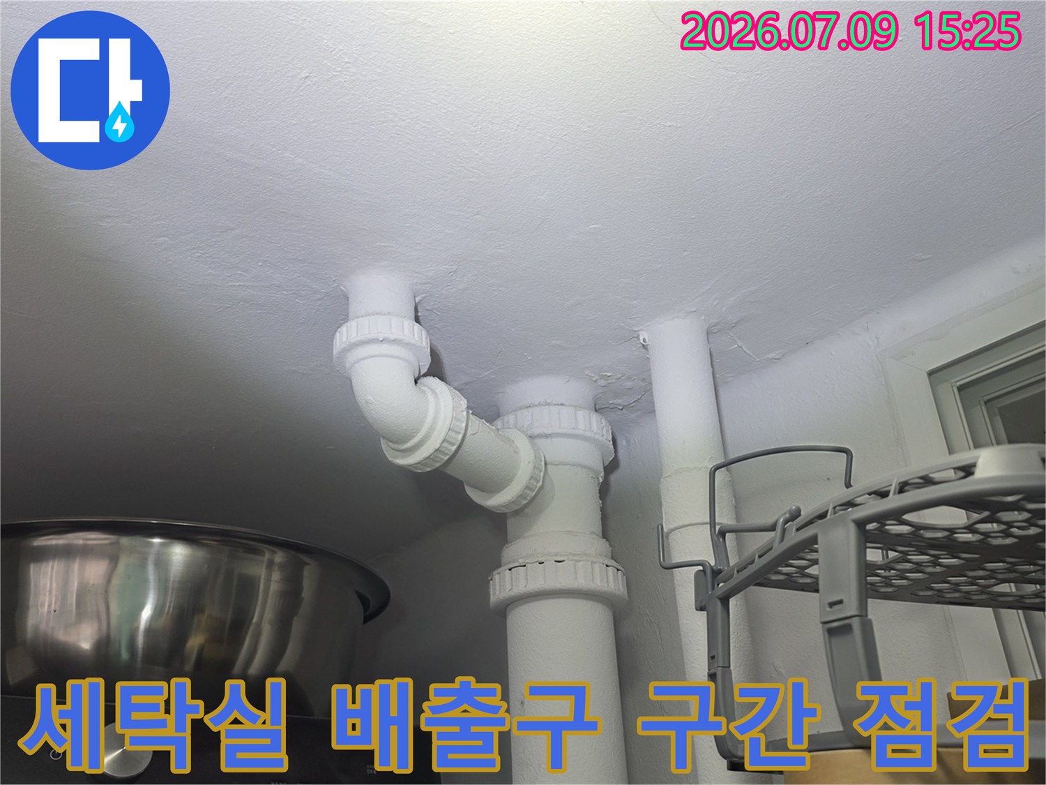 세탁기 하단의 굴곡부 및 수직 연결 부위를 정면으로 촬영한 사진입니다.