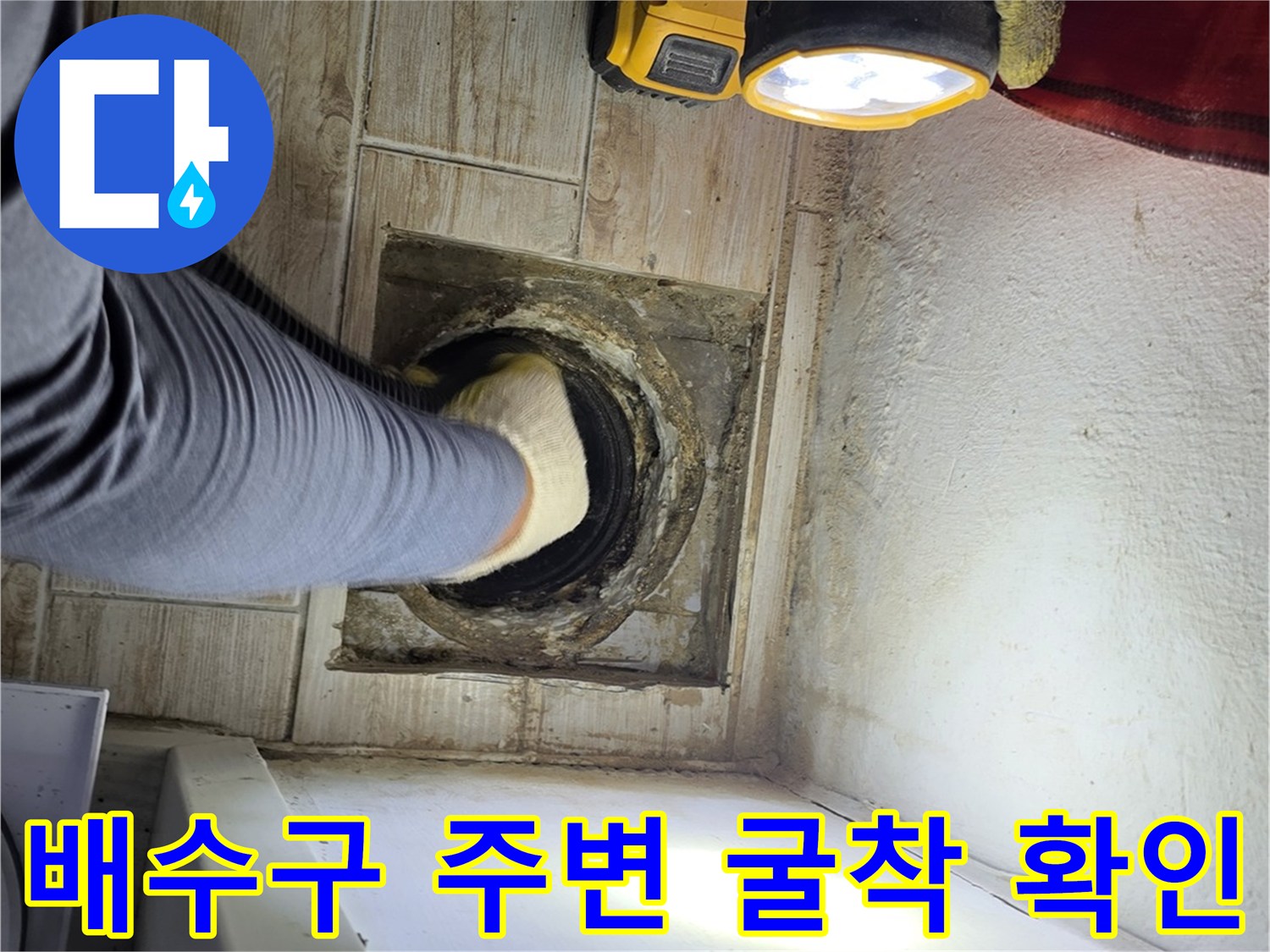 세탁실 배수구(유가) 주변을 파내고 노출된 배관 상태를 점검하는 모습