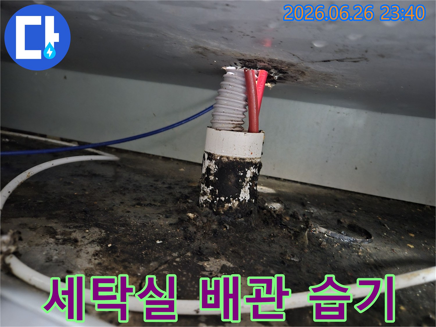 빌라 세탁실 배관 틈새에서 발생한 누수로 인해-주변에 형성된 짙은 습기와 오염 흔적을 보여줍니다.