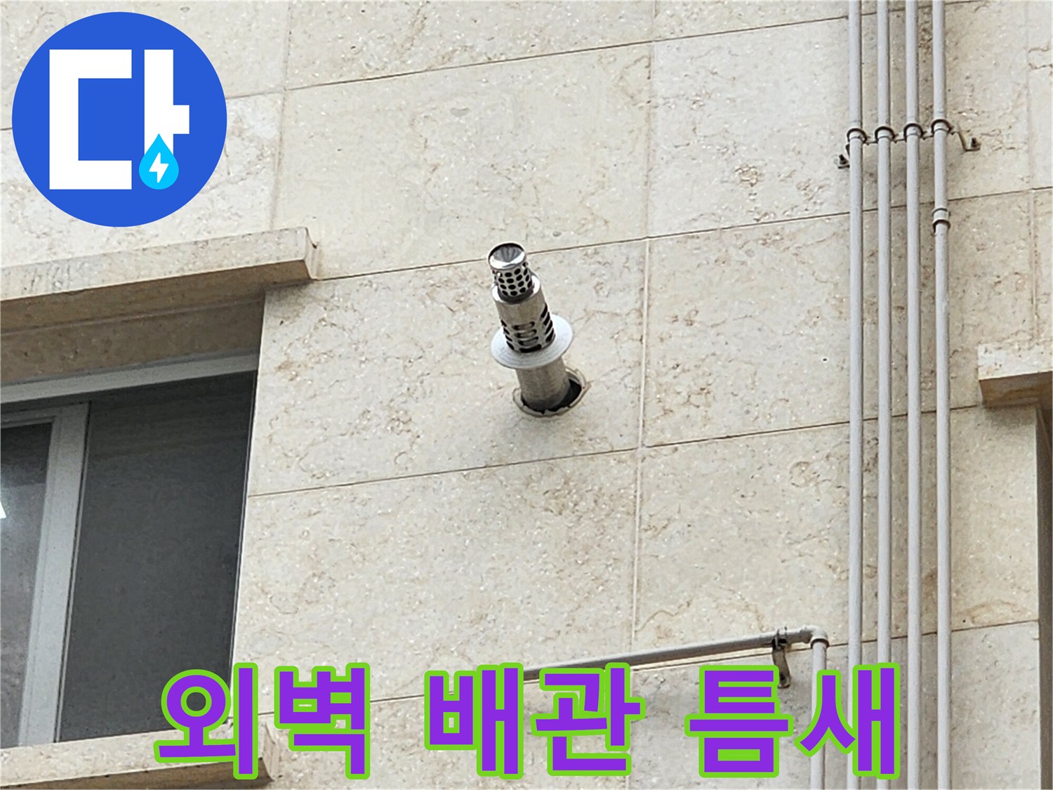 석재 마감된 벽면의 스테인리스 배수관 연결 부위 근접 촬영