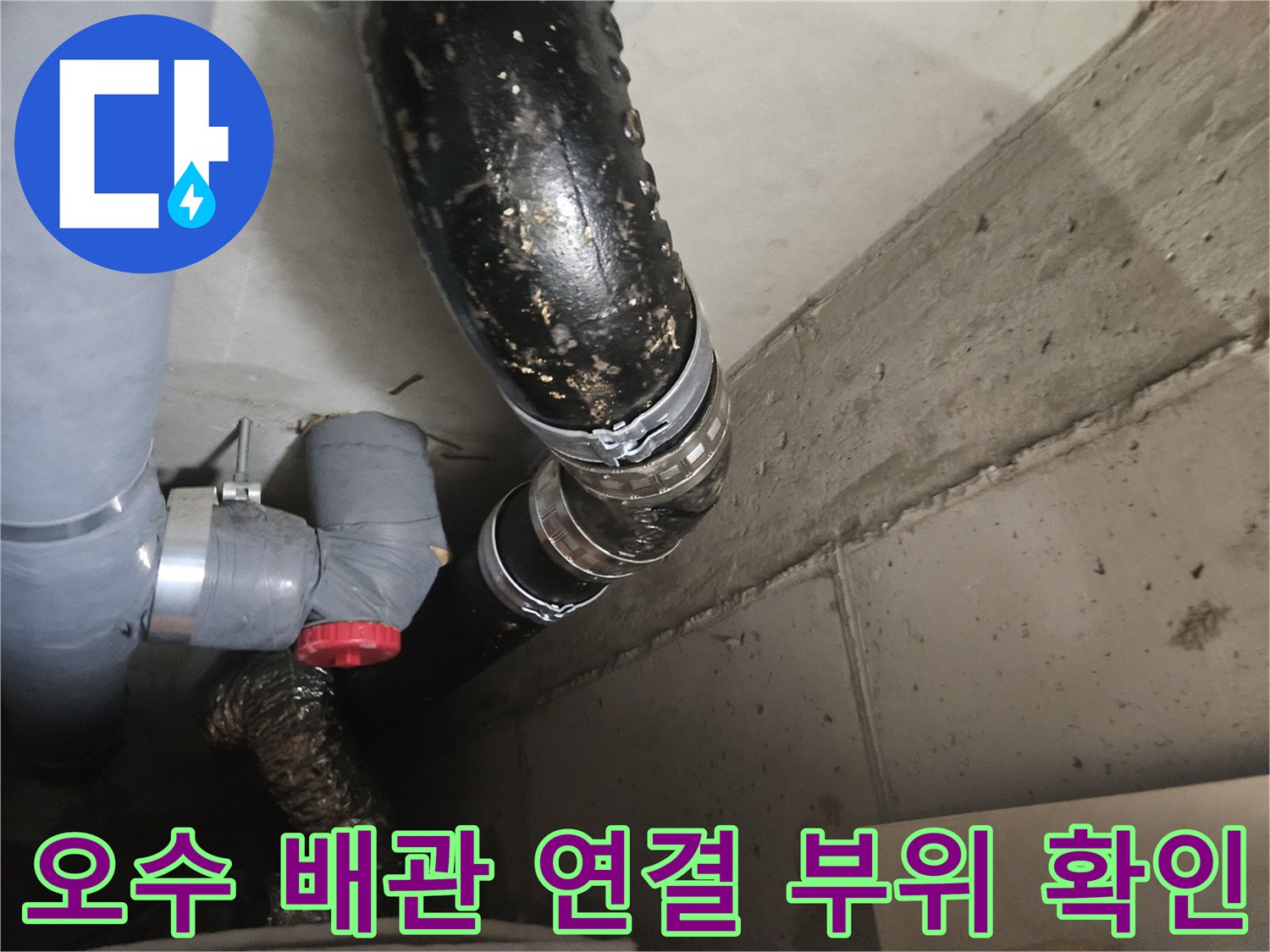 습기가 맺혀 있는 검은색 오수관과 회색 배관의 접합부