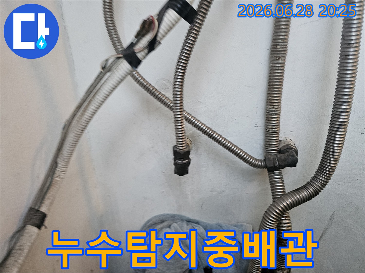 누수-전문-기술자가-벽에-설치된-다양한-배관들의-연결-상태를-정밀하게-확인하는-장면입니다.