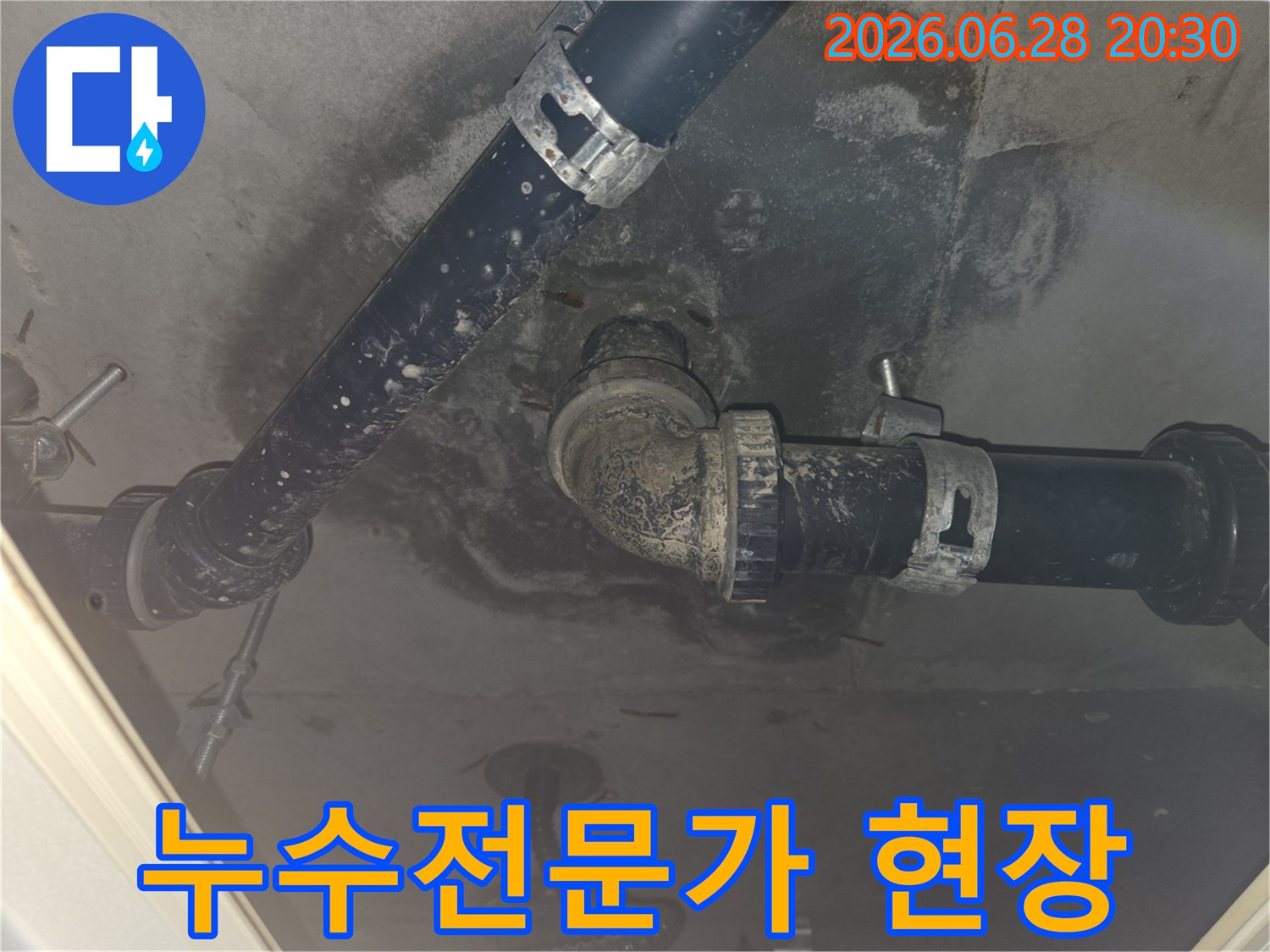 누수-전문가가-천장-배관의-누수-문제를-점검하고-있는-모습을-담은-사진