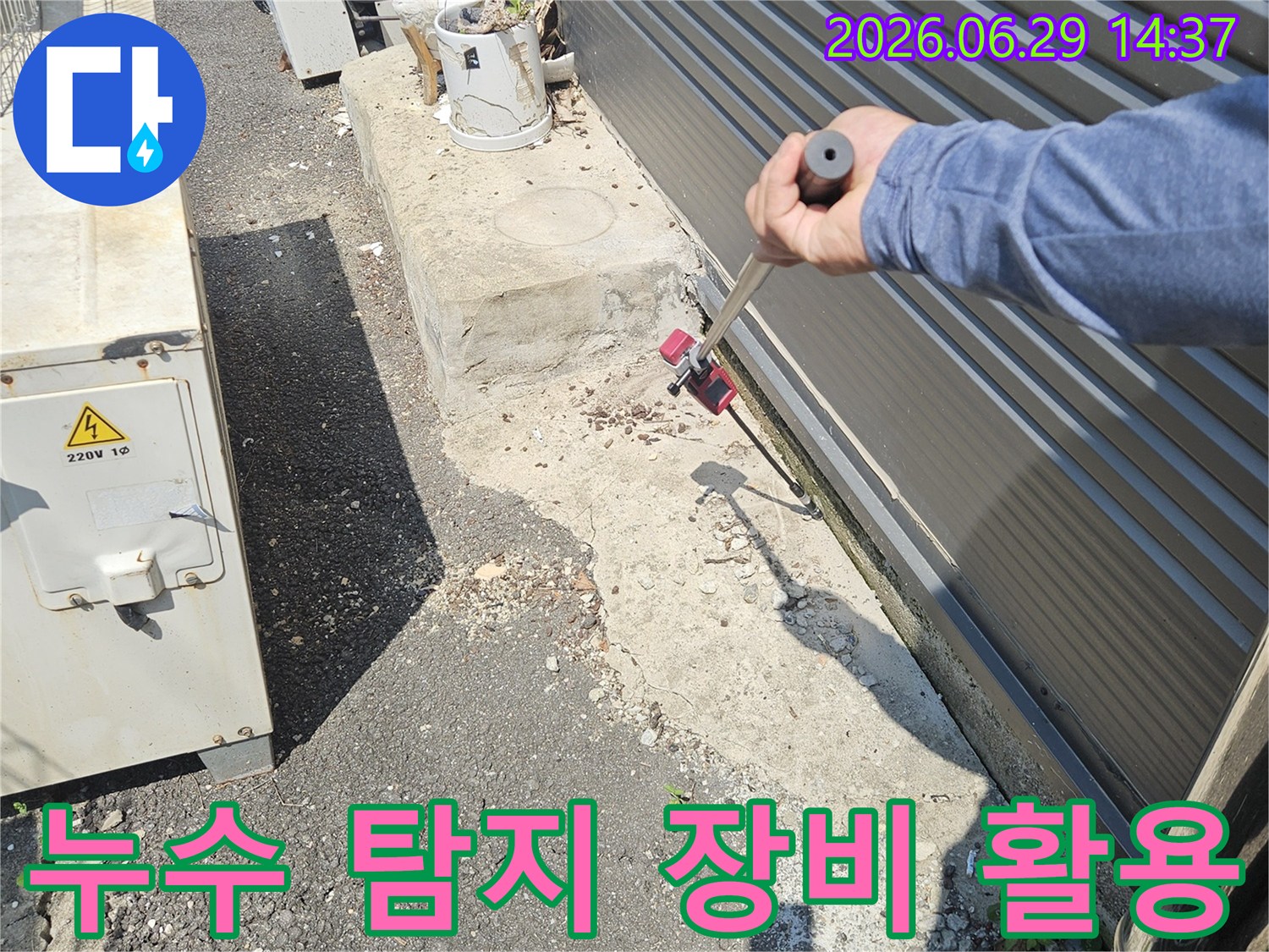 누수 엔지니어가-전문 탐지 장비를 이용해-건물 외부의 미세한 누수 흔적을-세심하게 확인하고 있습니다.