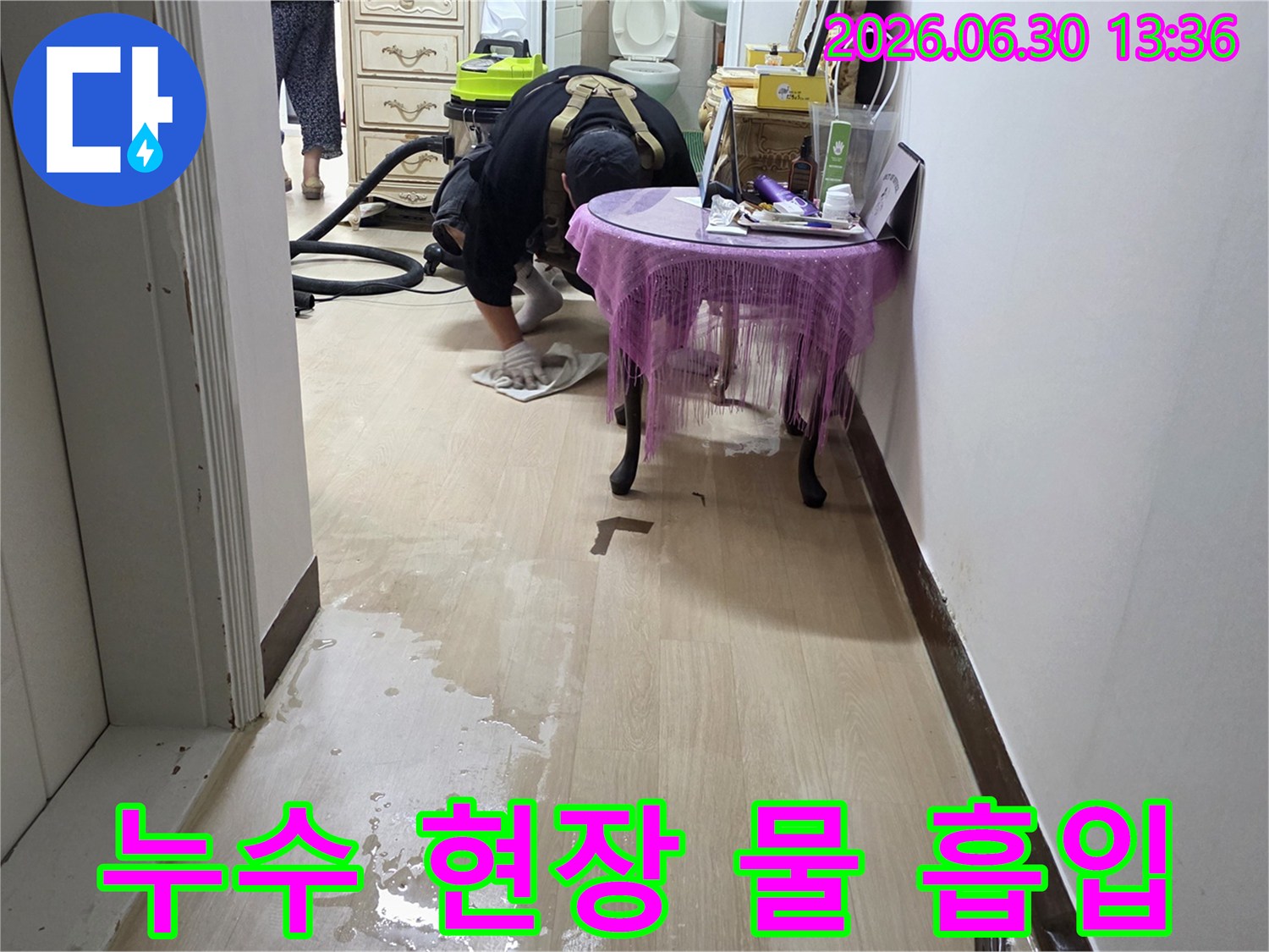 누수-전문가가-젖은-바닥의-물을-효율적으로-흡입하여-건조를-준비하는-장면