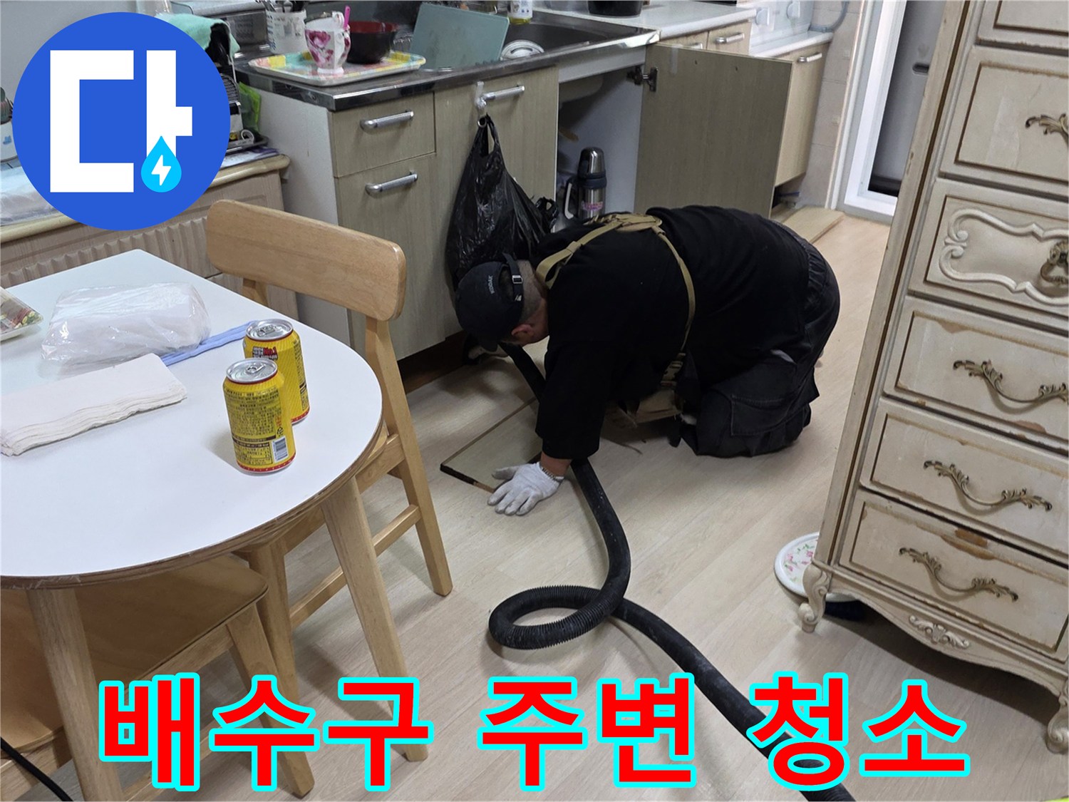 싱크대 밑 배수구의 물기를 제거하는 전문 작업자