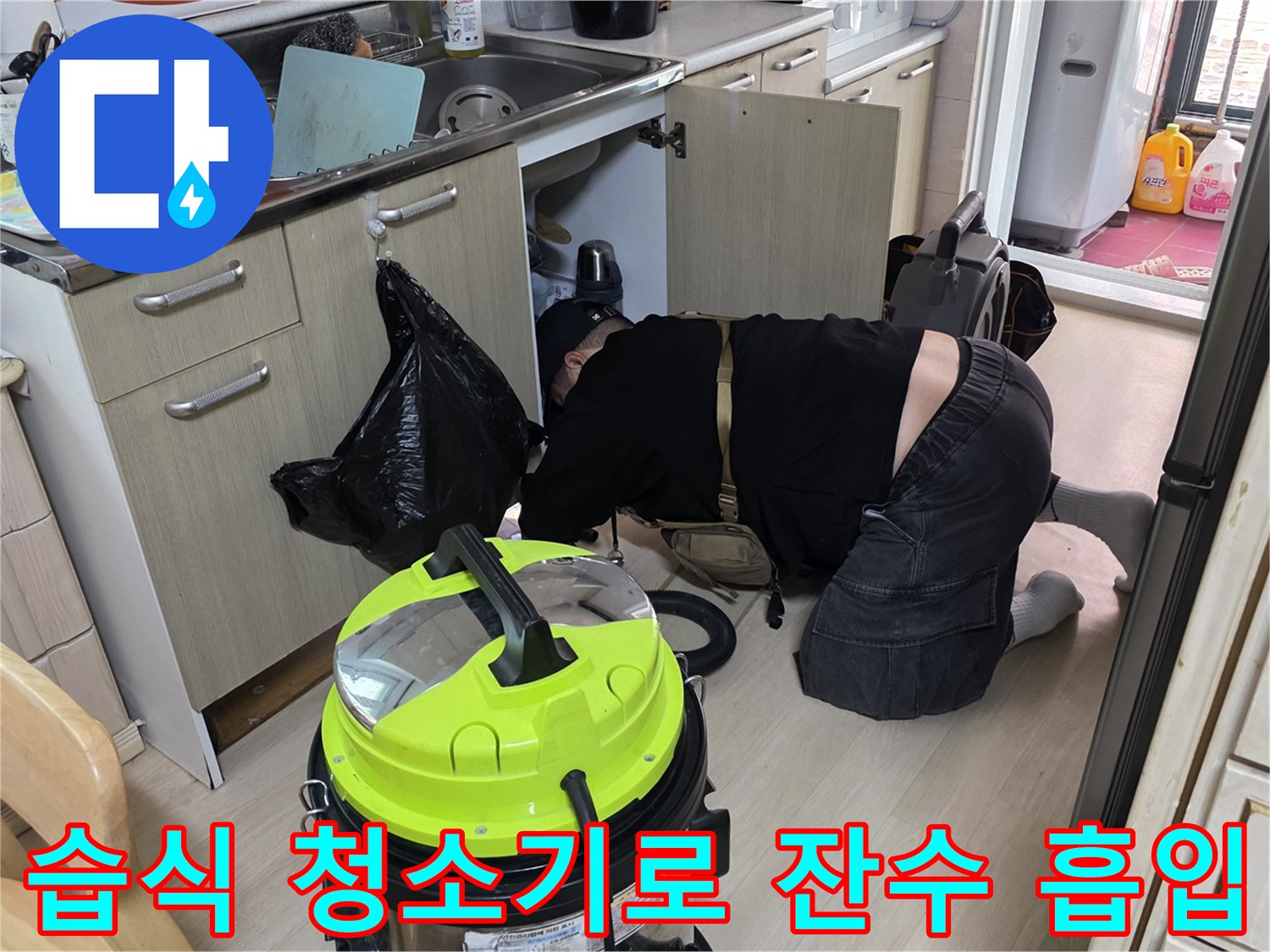 싱크대 아래 배관 주변의 오염된 물을 제거하기 위해 장비를 가동하는 장면