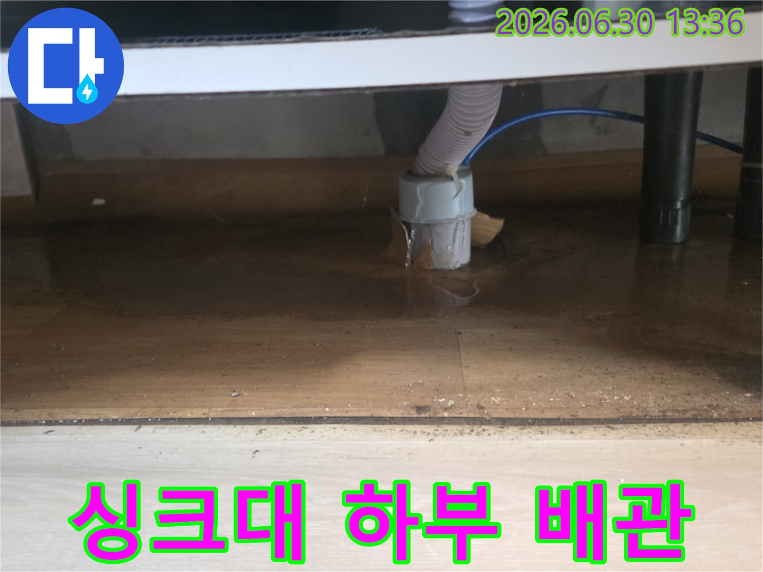 싱크대 하부 배수관 연결 부위에서 물이 새어-바닥에 고여있는-누수 현장의 모습입니다.