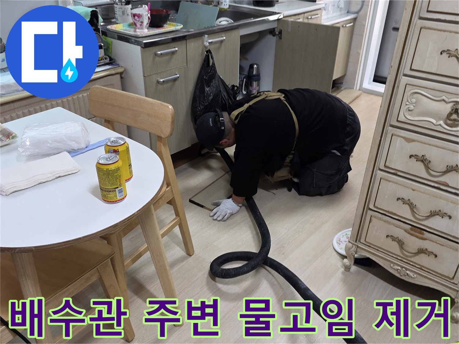 싱크대 하부장 아래 고여있는 물을 흡입하며 배관 상태를 점검하는 모습
