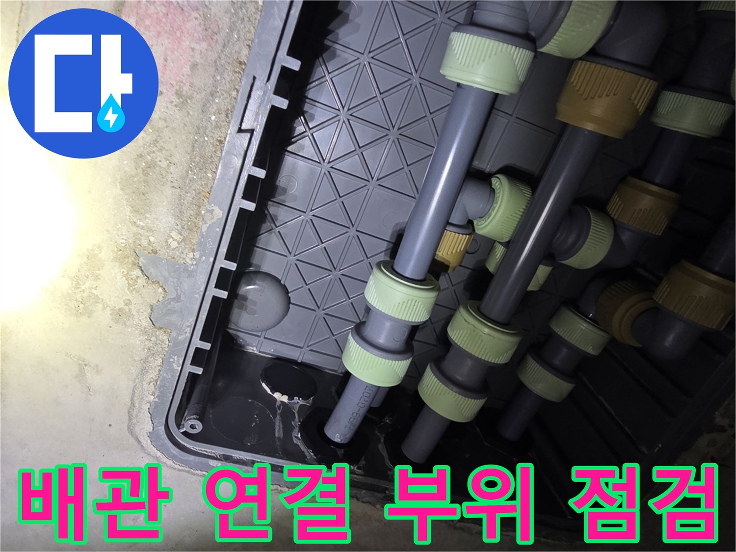 매립된 회색 배관의 분기점과 연결 소켓들이 모여 있는 모습입니다.