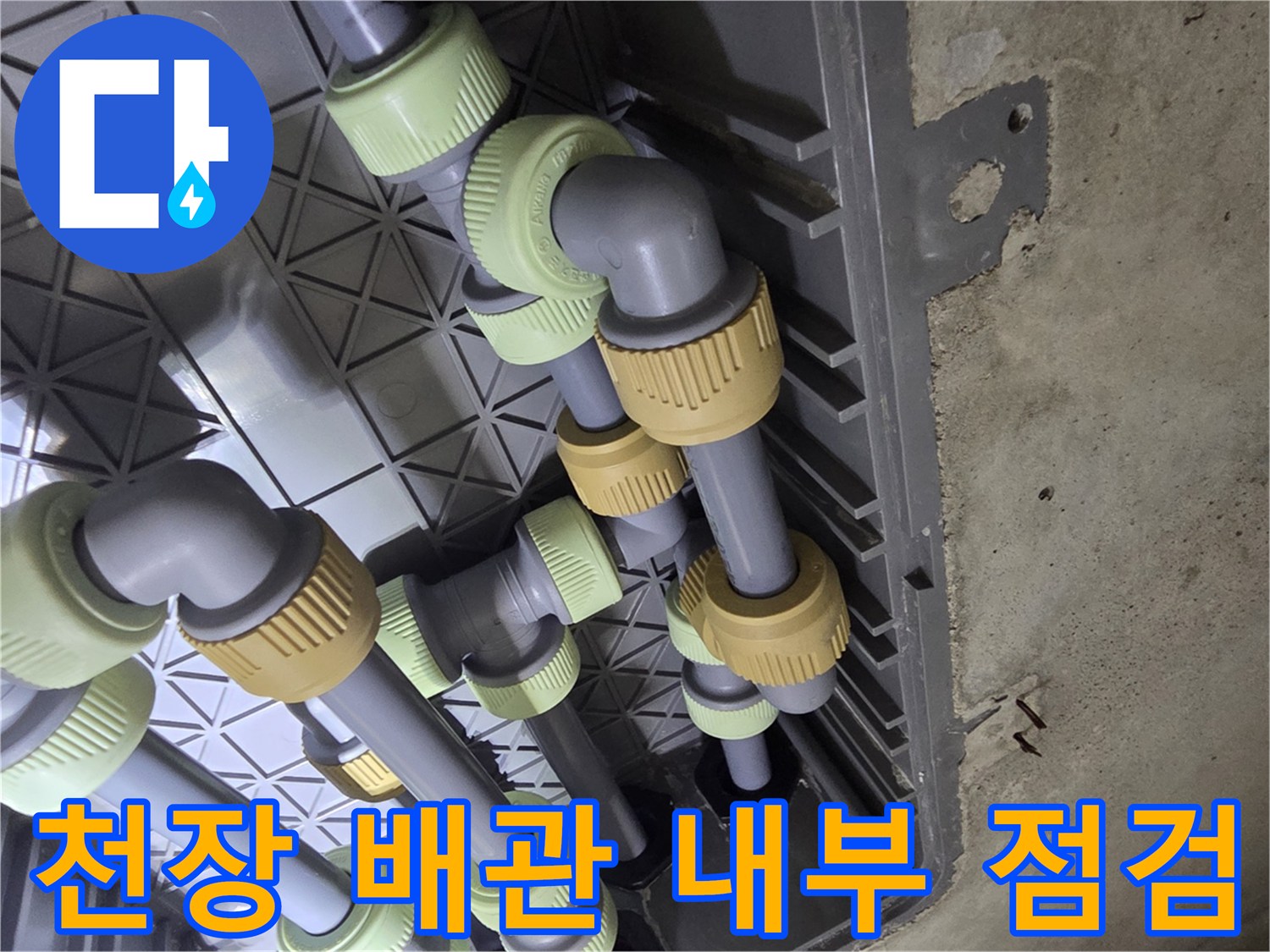 점검구 안쪽으로 보이는 회색 배관과 연결 부속들의 모습