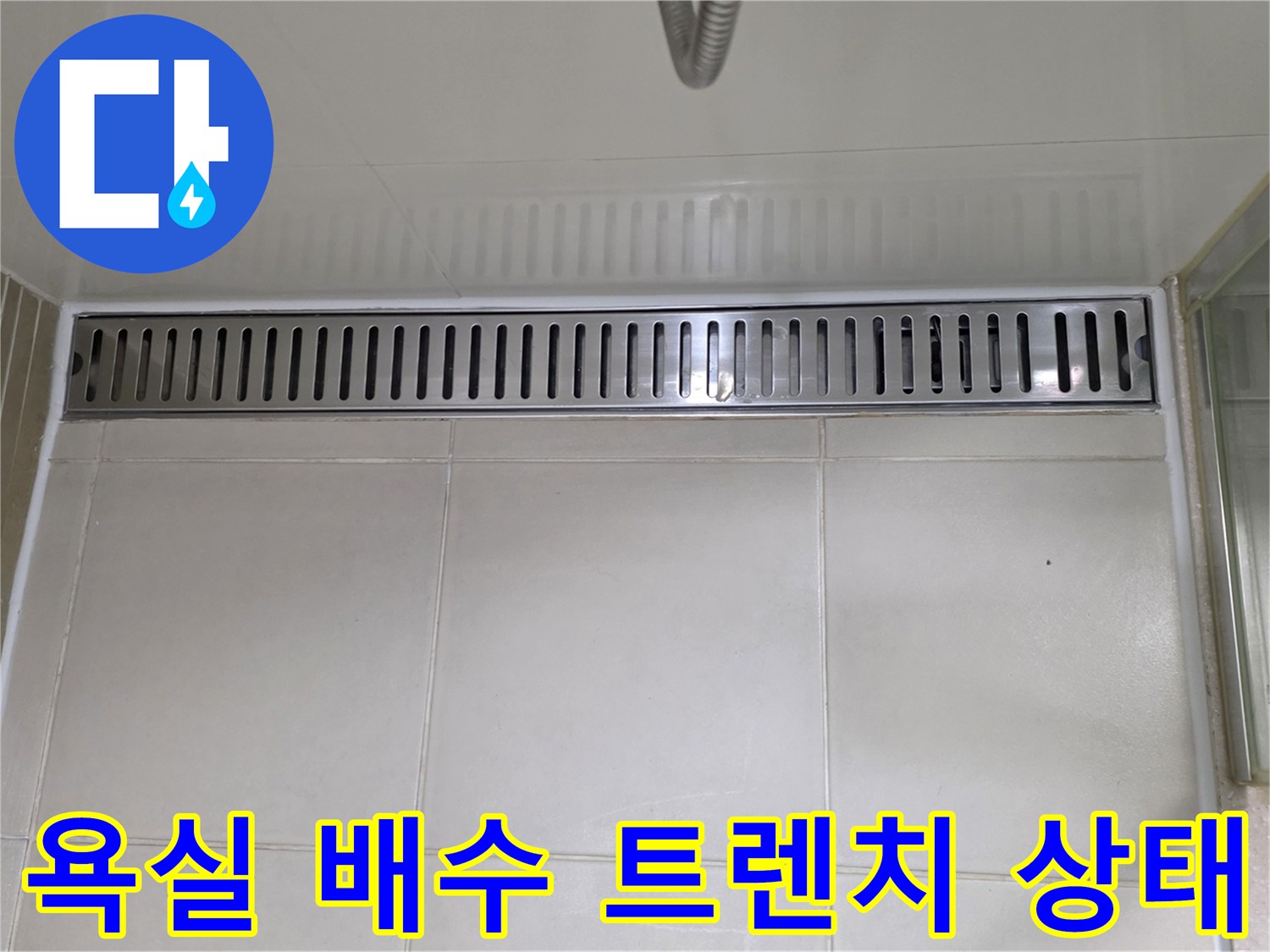 용산구 욕실 내부의 스테인리스 배수 트렌치와 타일 바닥 모습