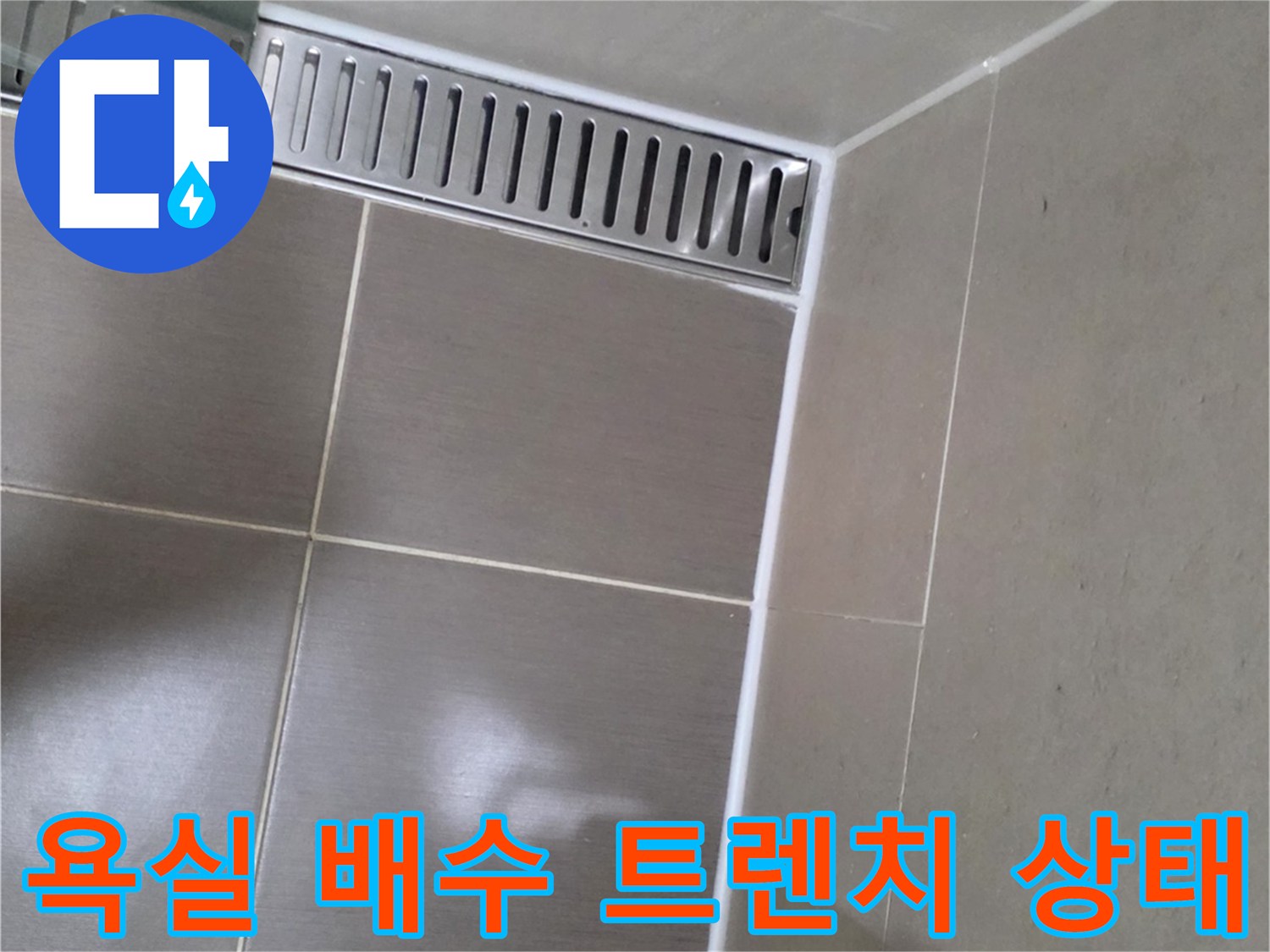 용산구 욕실 바닥의 배수 트렌치 및 타일 줄눈 부위 근접 촬영