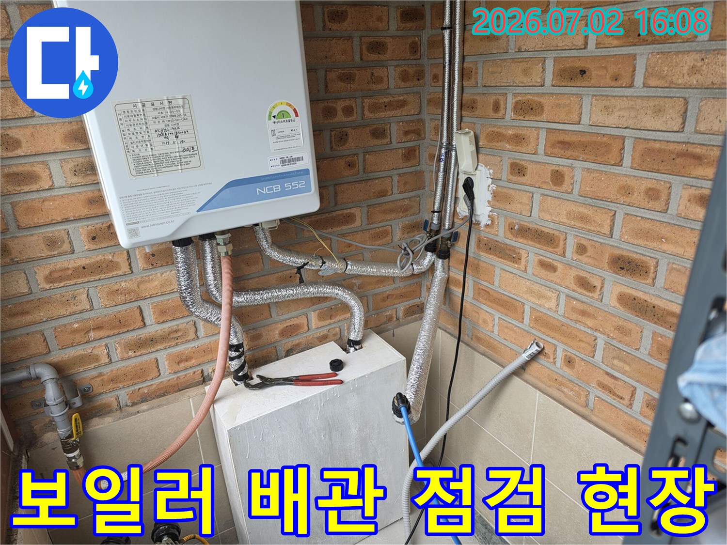 보일러에 연결된 노출 배관과 압력 테스트 장비가 배치된 모습