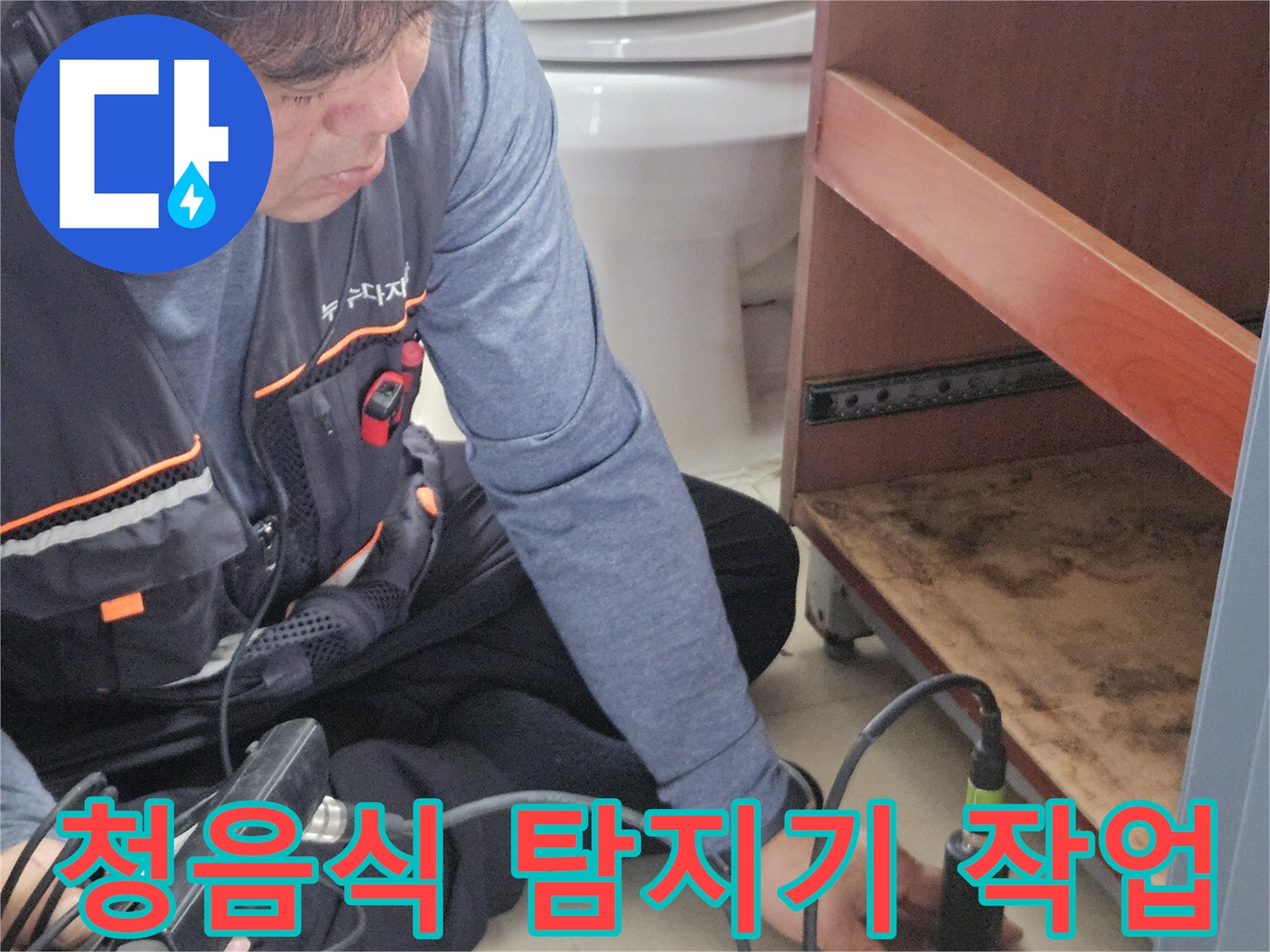 엔지니어가 청음식 탐지기를 사용하여 세면대 하부 배관의 소리를 듣고 있습니다.