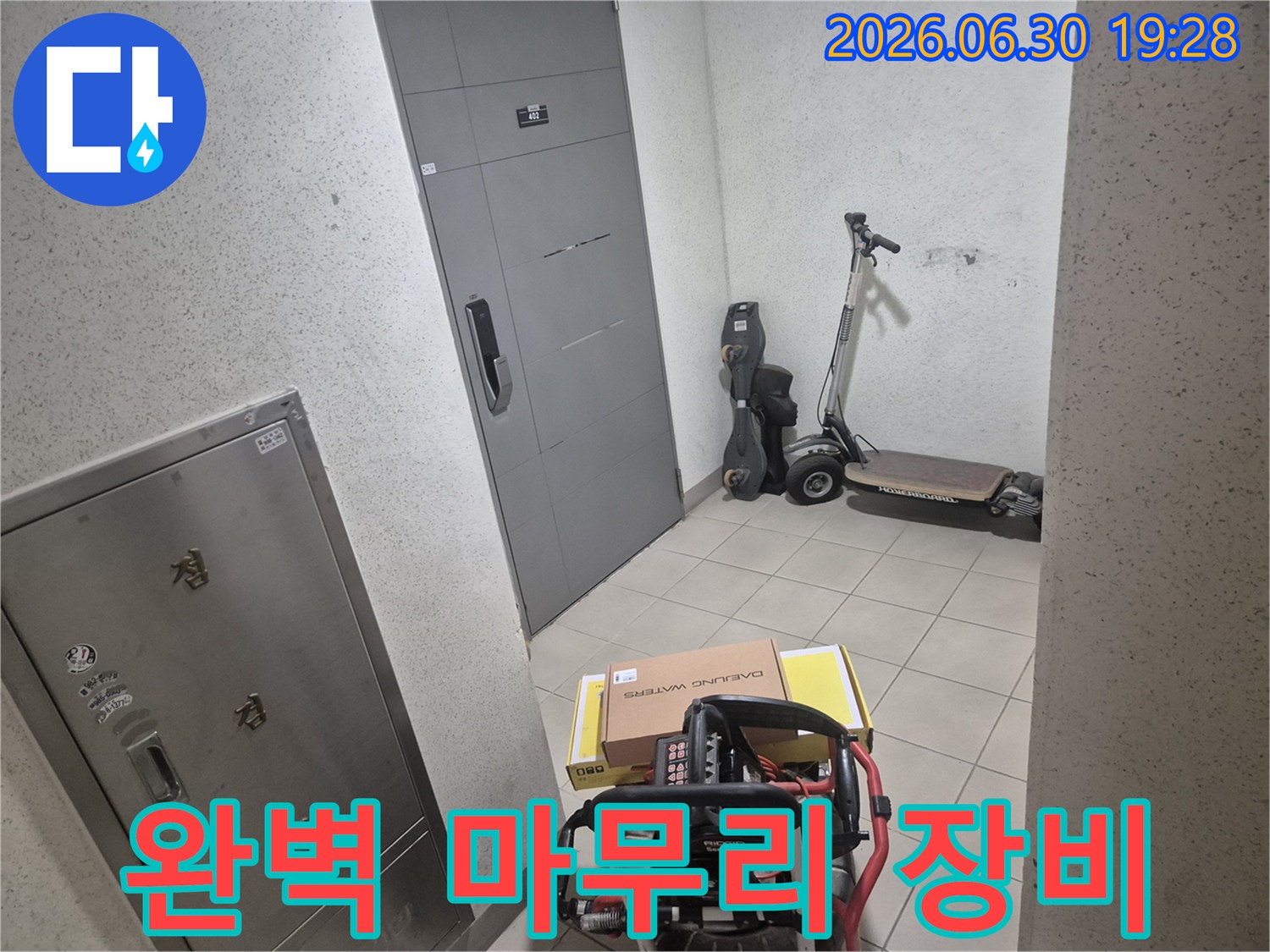 전문 엔지니어가-고객님 댁 현관에서-누수 탐지부터 보수까지-완벽한 마무리를 위한 장비를 준비하고 있습니다.