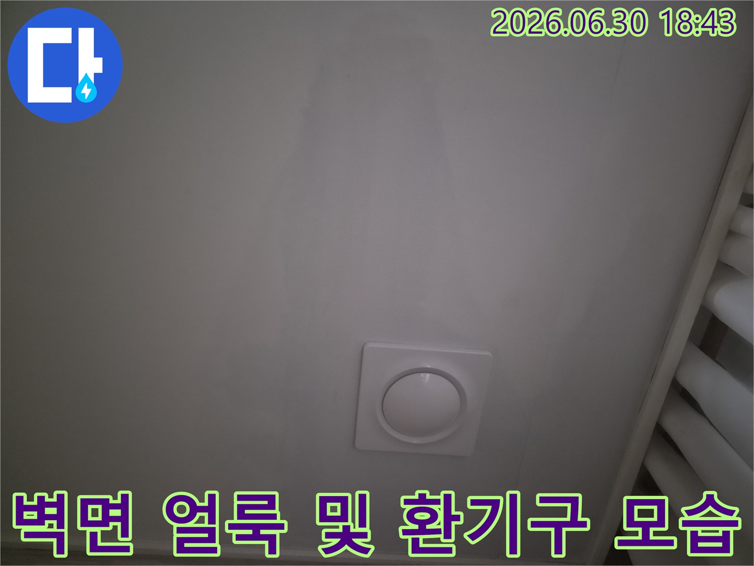 천장 벽면에 물이 스며들어 생긴 큰 얼룩과 흰색 원형 장치