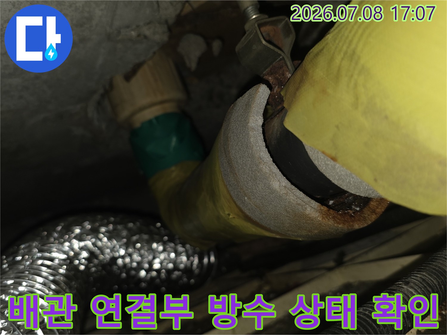 배관 연결 지점의 누수 여부를 판단하기 위해 구조를 살피는 장면
