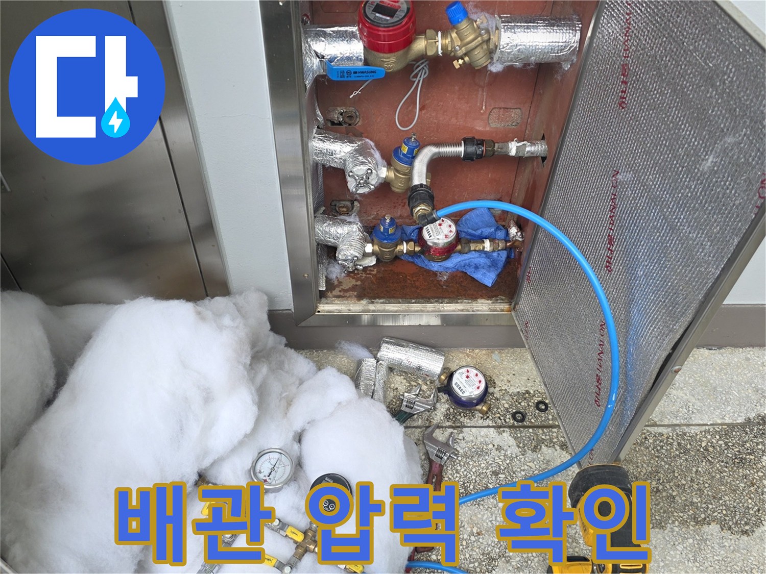 수도 배관의 연결부와 압력계를 통해 누수를 진단하는 모습