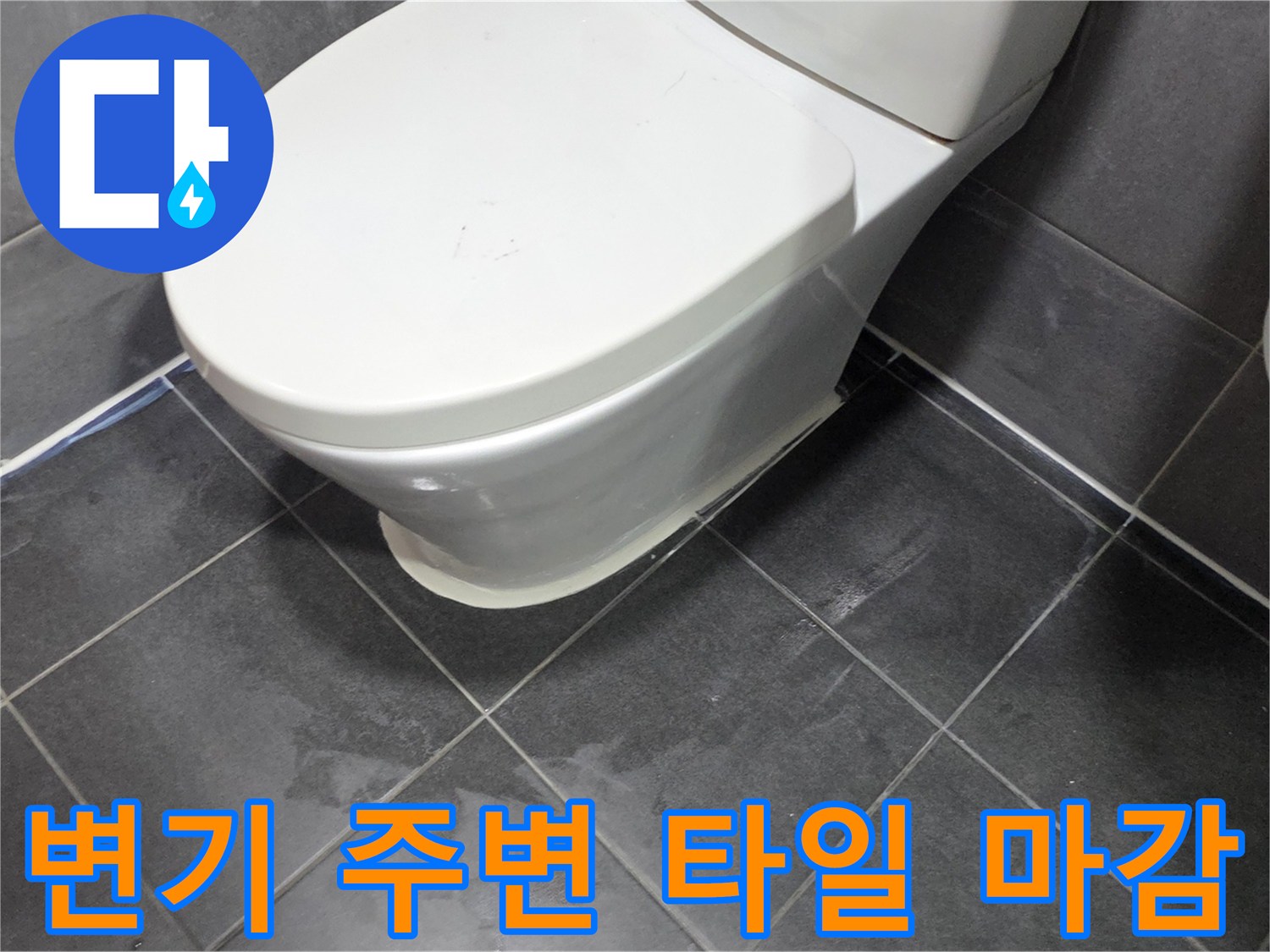 화장실 변기 하단부와 회색 타일의 접합면 사진입니다.
