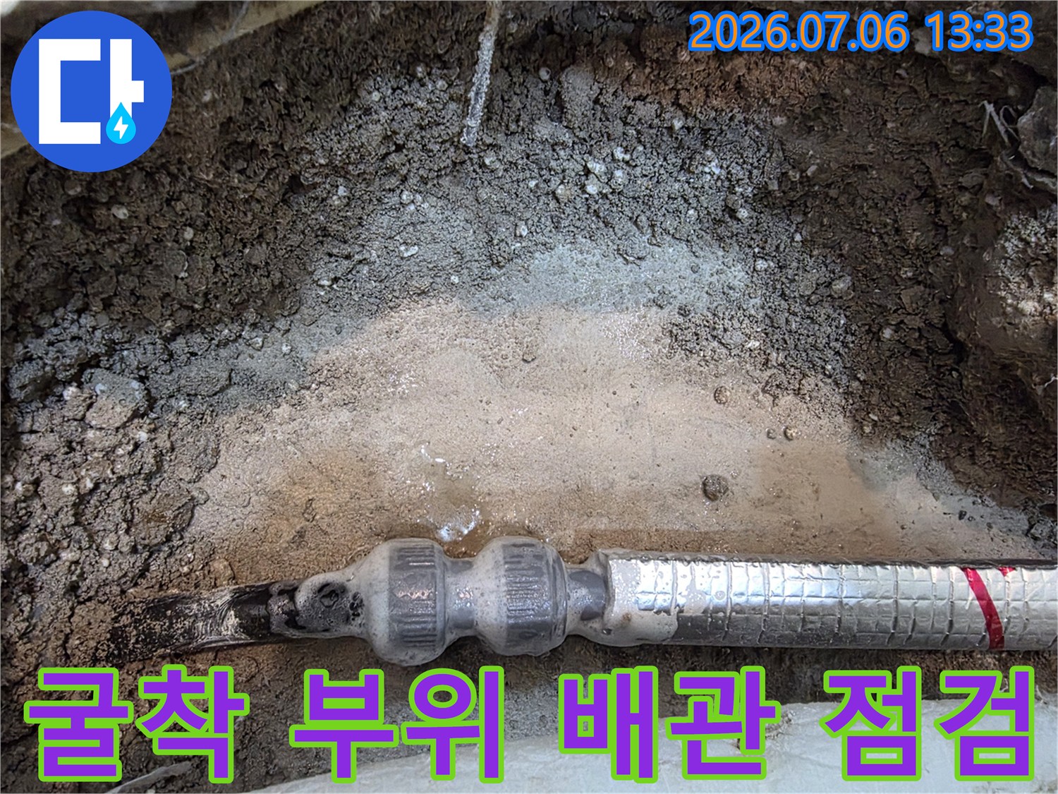 노란색 띠가 있는 보온재 배관과 젖은 토사 구간