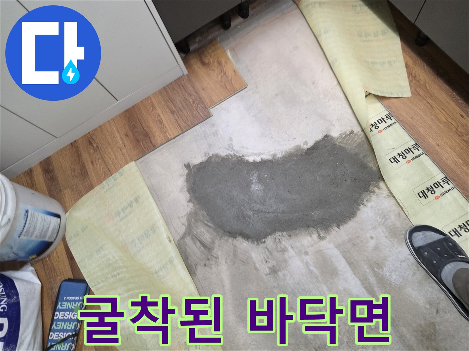 바닥재 아래 젖은 콘크리트가 드러난 모습