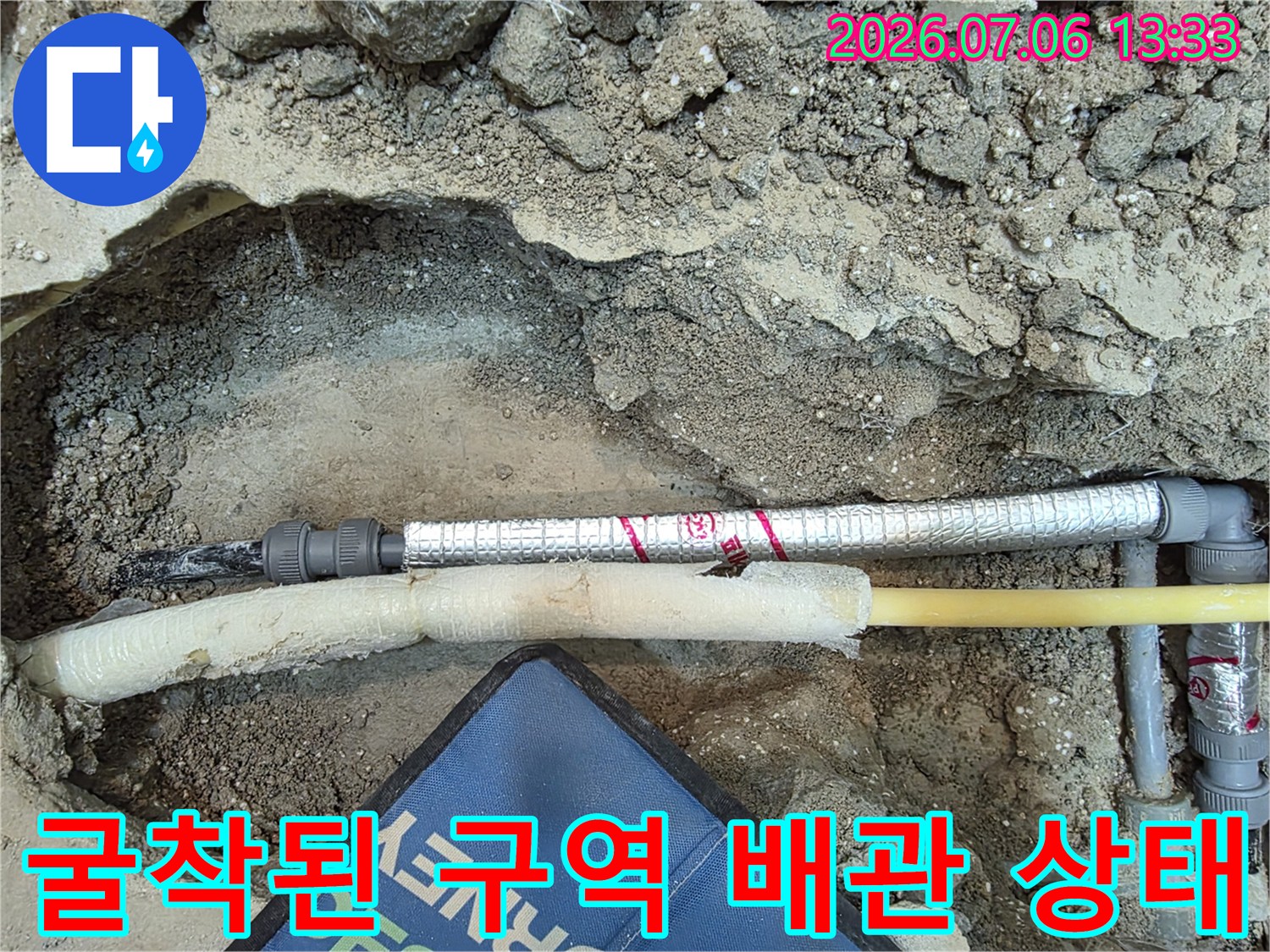 수리 예정인 구간의 노출 배관과 주변 흙을 정리한 작업 현장
