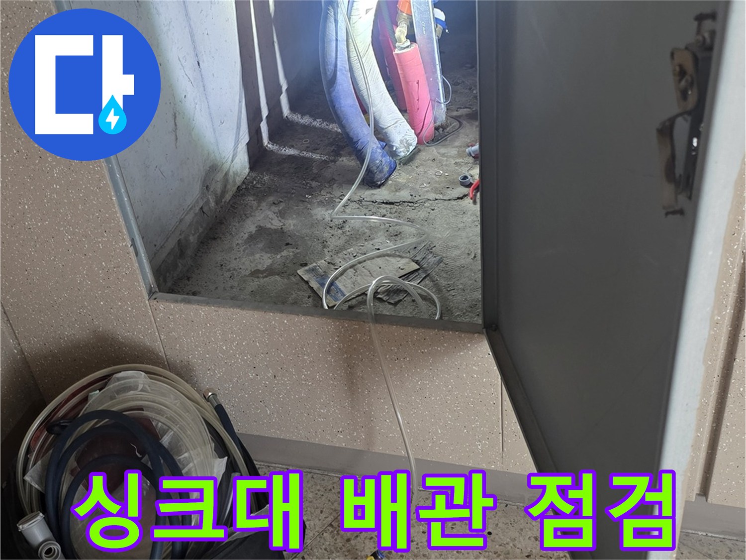 싱크대 하부장 내부-공압 테스트를 위해 연결된 배관 장비