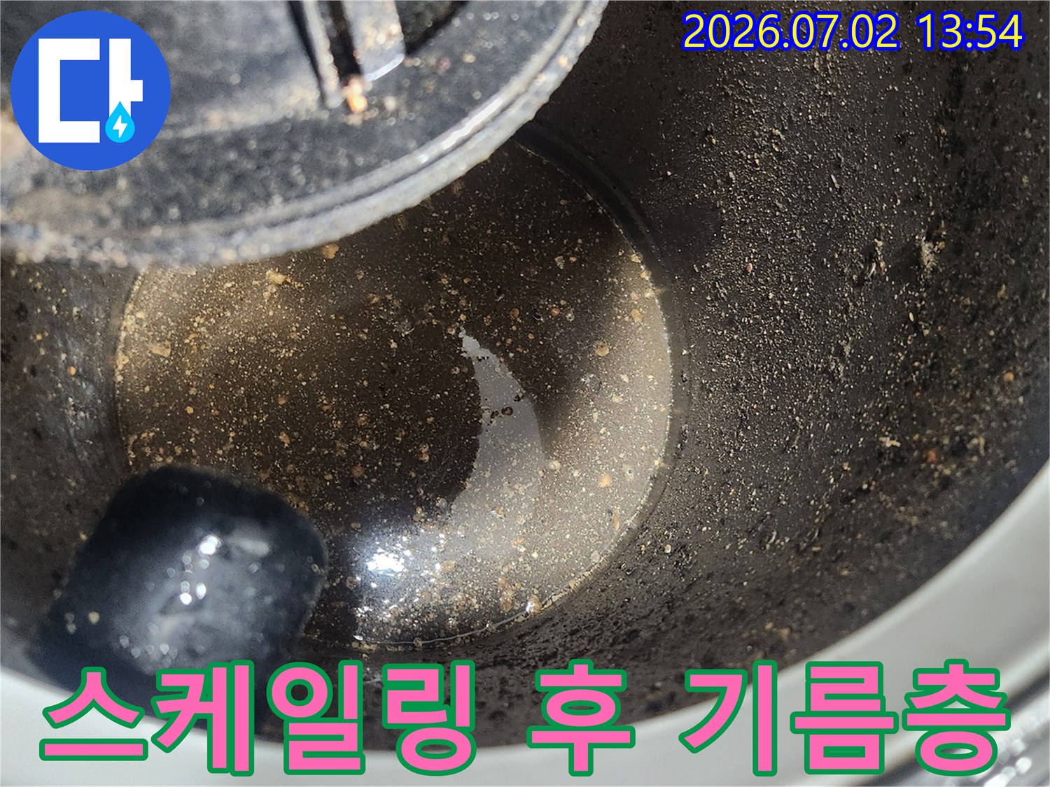 배관 스케일링 1차 작업 완료 후-석션 장비 내부에 포집된-굳은 기름층과 오염물질을 보여주는 클로즈업 사진