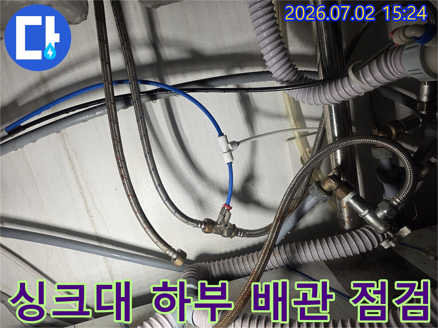 상태가 노후된 싱크대 아래 급수 호스와 연결 부위를 점검하는 모습